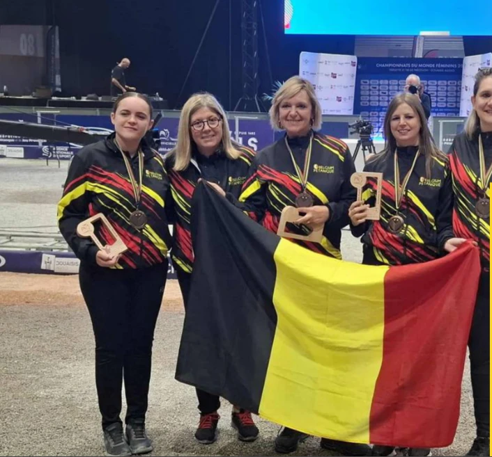 Vijf Belgische dames met medailles om de hals en de Belgische vlag tijdens een wereldkampioenschap