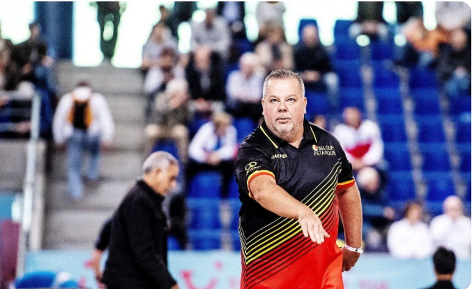 Belgische speler kijkt geconcentreerd naar het terrein, met tribunes erachter